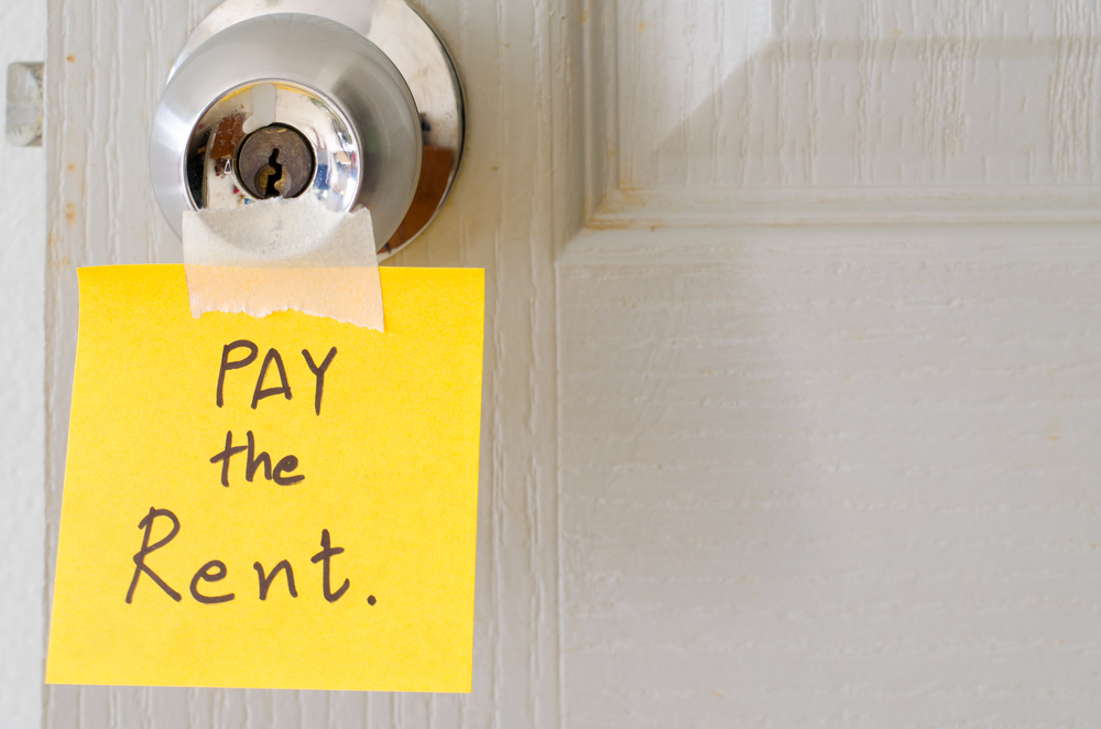 sticky note write a message pay the rent on the latch door